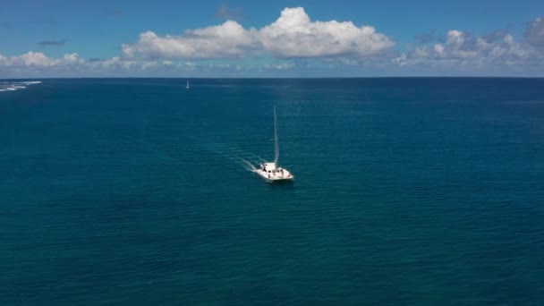 Catamarán en aguas turquesas sobre el fondo de la paradisíaca isla Mauricio. Imágenes de drones vista aérea superior del catamarán navegando en mar abierto. — Vídeo de stock