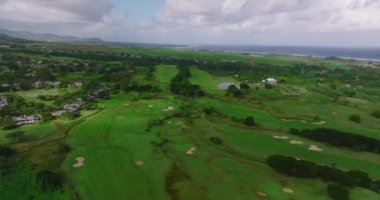 Golf oteli kıyısı Hint Okyanusu. Sahilde golf sahası ve villalar. Golf sahasının havadan görüntüsü. Atış yapmak, golf kulübünün üzerinde uçmak. Yaz zamanı, gün batımı. Zengin insanların hayatı. Mauritius.