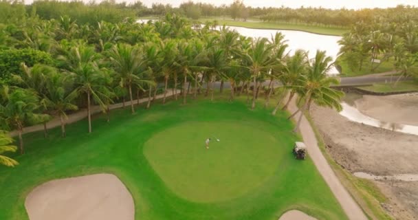 鸟瞰高尔夫球场 绿草绿树林立 夏日阳光灿烂 鸟瞰高尔夫球场 令人惊奇 海滩上的绿地和别墅 高质量的4K镜头 — 图库视频影像