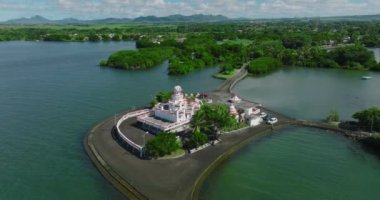 Hint Okyanusu 'ndaki bir Hint tapınağının, yemyeşil bir bitki örtüsünün ortasındaki yemyeşil bir gölün, bulutların arkasındaki görüntüsü. Hint mimarisinin arka planı, yakın plan. Yüksek kalite 4k görüntü