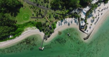 Turkuaz su ve canlı resifle güzel, yeşil Mauritius adasının havadan görünüşü. Hint Okyanusu kıyısındaki lüks otellerde. Tatil, seyahat, gün batımı.