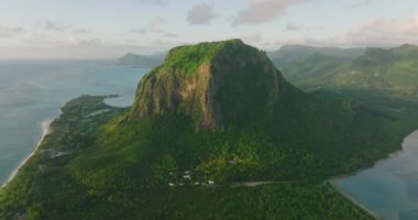 Hava görüntüsü. Manzarası vahşi doğa kayalık dağları, yoğun yeşil orman ağacı ve palmiyesi olan tropik bir ada. Birçok ağacı olan modern ve ekolojik yeşil alanlar. Yeşil palmiyeler ve diğer bitkiler.