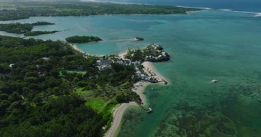 Turkuaz su ve canlı resifle güzel, yeşil Mauritius adasının havadan görünüşü. Hint Okyanusu kıyısındaki lüks otellerde. Tatil, seyahat, gün batımı.