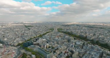 Paris üzerinde uçan bir dronun görüntüsü. Dünyanın en popüler şehrinin şehir manzarası. Ufuk çizgisinde evler ve gökdelenler var. Bir İHA 'dan sinematik çekim. Yüksek kalite 4k
