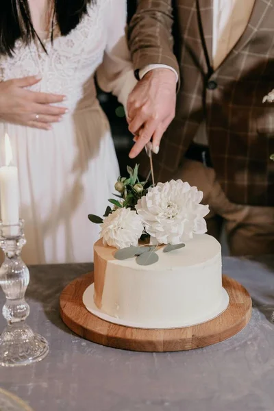 Gelinlik giymiş gelin ve damat düğün pastasını bıçakla kesti.