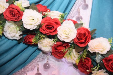 Beyaz ve kırmızı yapay güller, yeşil deniz dekoratif perdeler, dekorasyon tasarımı düğünü.