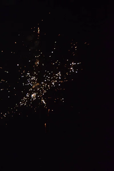 Wit vuurwerk, spetters licht aan de zwarte nachtelijke hemel, vakantie — Stockfoto