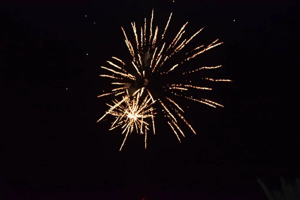 Goudgeel vuurwerk, spatten licht aan de zwarte nachtelijke hemel, vakantie — Stockfoto
