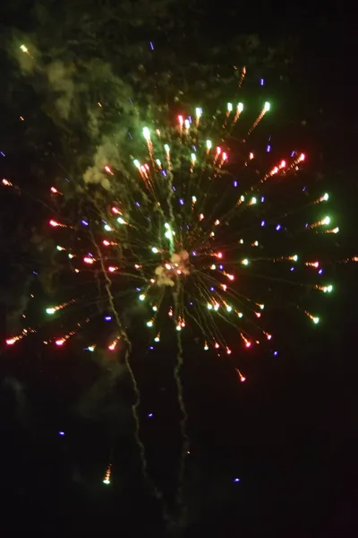 Κόκκινα-άσπρα-πράσινα πυροτεχνήματα, πιτσιλιές φωτός στο μαύρο νυχτερινό ουρανό, διακοπές — Φωτογραφία Αρχείου