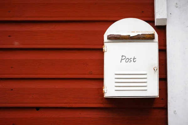 メールボックス 木製の赤い家の壁の背景にポストボックス 小さな村で郵便サービス ホワイト 錆びた金属 田舎の郵便箱 スパム 新聞の送信 スペースをコピー — ストック写真