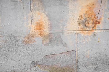 Hasarlı gri duvar, turuncu boya sıçrama desenli arka plan. Yaratıcı bir zemin. Eski binanın iç kısmı. Yıpranmış ve çatlamış tuğlalar betonla kaplanmış ve boyası soyulmuş. Kapat, boşluğu kopyala