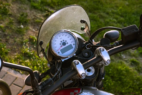 Motorcycle speedometer and dashboard with wind glass. Shiny, custom, stylish, yellow motorbike panel fragment close up. Retro design transportation. Freedom, speed and vehicle repair workshop concept