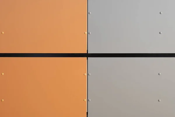 Orange and grey metal wall texture background. Modern building wall from metal plates. Different square sections on the wall. Close up with copy space for design