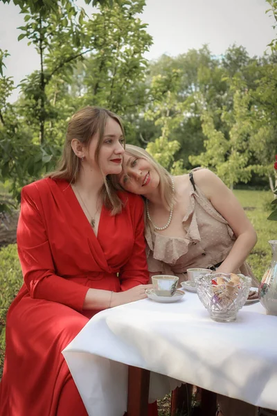Bahçede çay içen iki kız arkadaş
