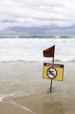 Deniz sarısı uyarı işareti ve kırmızı bayrak..