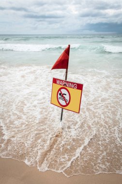 Deniz sarısı uyarı işareti ve kırmızı bayrak..
