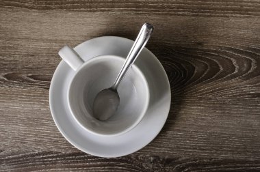 Kahverengi tahtada bir fincan kahve.