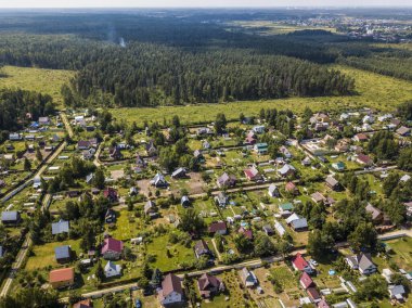 Şehrin en iyi insansız hava aracı manzarası. Modern Avrupa mimarisi. Gün batımında yeşil orman.