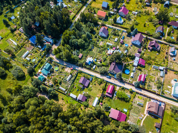 Top drone panorama view of of private sector of city. Modern european architecture. Green forest in sunset light.