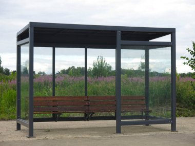 Köydeki otobüs durağı köşkünde vazosu olmayan bir bank.