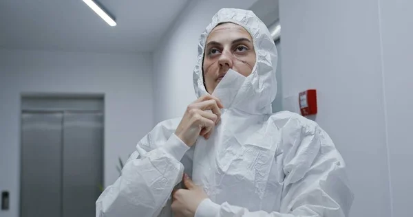 Zmęczona Pielęgniarka Zakładająca Biały Kombinezon Ochronny Szpitalu Podczas Pandemii Koronawirusowej Zdjęcia Stockowe bez tantiem