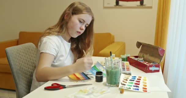 女の子は思慮深く自宅で着色された塗料で絵を描く — ストック動画