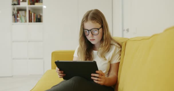 Ung Blond Pige Iført Briller Sidder Komfortabel Sofa Derhjemme Ved – Stock-video
