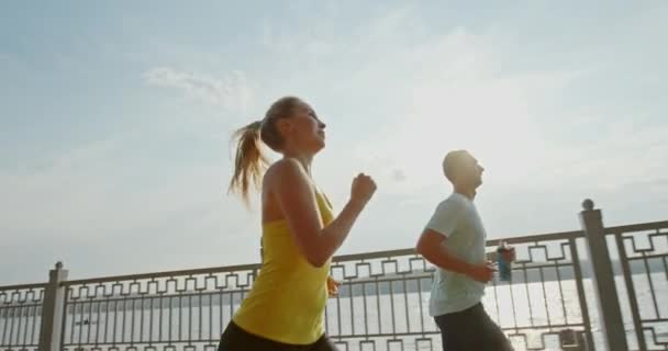Powolny Ruch Atletycznego Mężczyzny Kobiety Biegających Razem Przeciwko Ogrodzeniu Miejskiego — Wideo stockowe