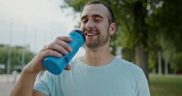 Feliz Deportista Bebiendo Agua Cerca Del Parque Corredor Masculino Positivo — Vídeos de Stock