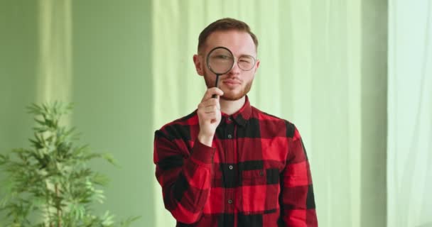 Gözlüklü Kareli Tişörtlü Komik Genç Adam Kameraya Büyüteç Büyüteç Araştırmacısı — Stok video