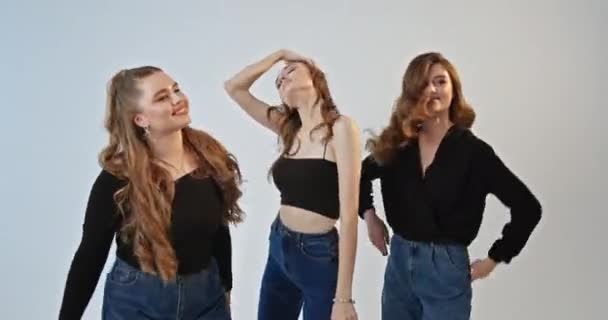 Молодые Девушки Стильных Нарядах Танцуют Вместе Веселясь Сером Фоне — стоковое видео
