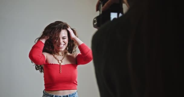 Приваблива Кучерява Жінка Червоній Блузці Грає Збудження Позуючи Професійному Фотографу — стокове відео