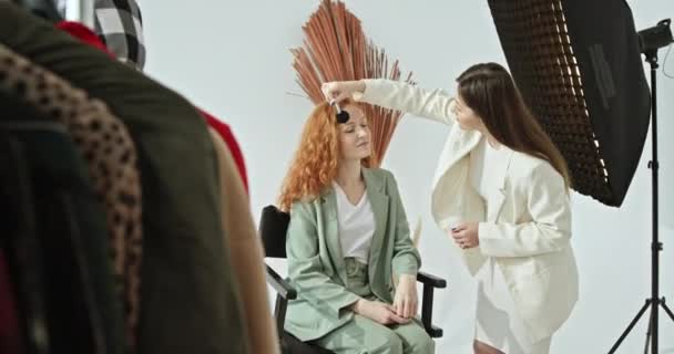 Mujer Artista Maquillaje Chaqueta Blanca Prepara Modelo Pelo Rojo Bastante — Vídeos de Stock