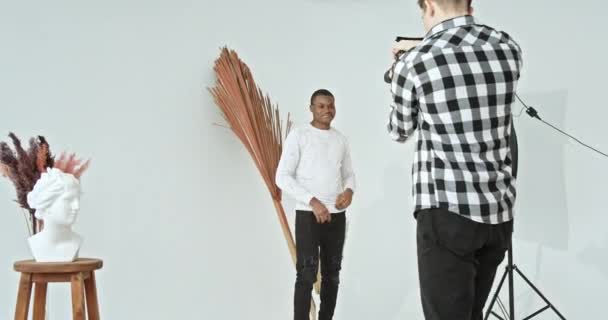 Молодий Чоловічий Фотограф Фотографує Демонструє Кадри Позитивному Чорному Чоловікові Сучасній — стокове відео