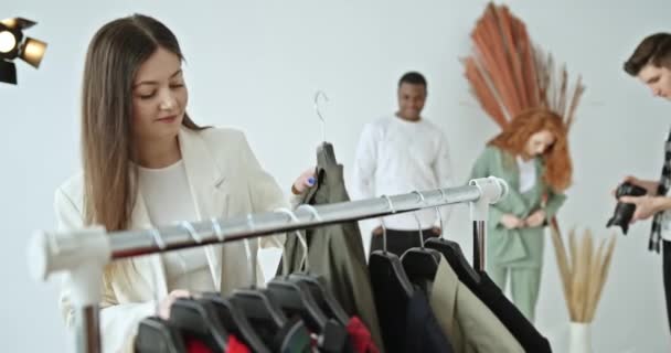 Fotografia Profissional Nos Bastidores Estilista Seleciona Roupas Para Modelos Multirraciais — Vídeo de Stock