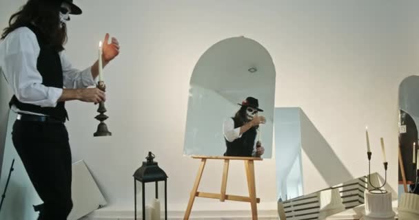 Espeluznante Hombre Con Una Vela Sus Manos Mira Espejo Estudio — Vídeos de Stock
