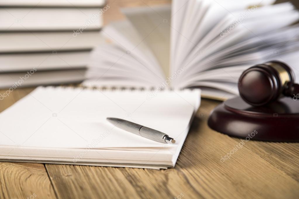 Wooden gavel, Lady Justice, gold scale and law books on wooden table