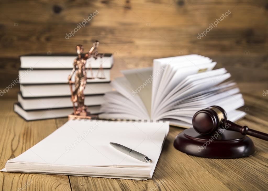 Wooden gavel, Lady Justice, gold scale and law books on wooden table