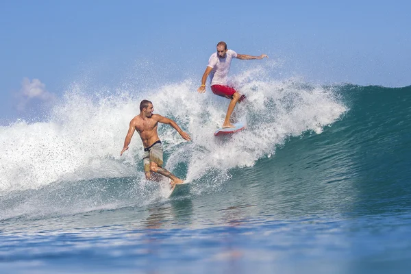 Surffaajat aalloissa — kuvapankkivalokuva