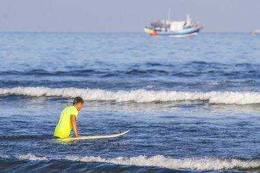 Surfer with his surfboard clipart