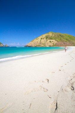 Kumsalda yürüyen genç bir kadın