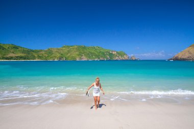 Kumsalda yürüyen genç bir kadın