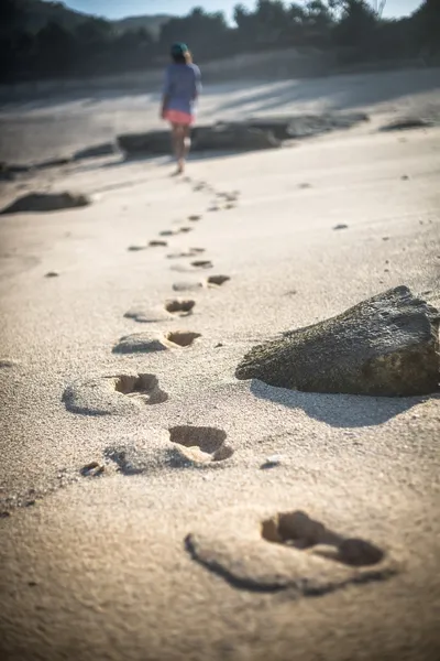 Mulher caminha sozinha em uma praia deserta — Fotografia de Stock