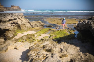 kadın, tek başına ıssız bir kumsalda yürür