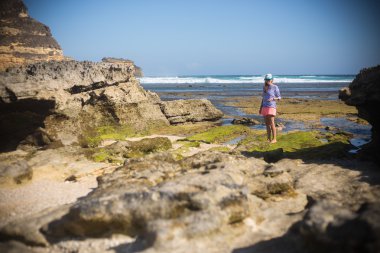 kadın, tek başına ıssız bir kumsalda yürür