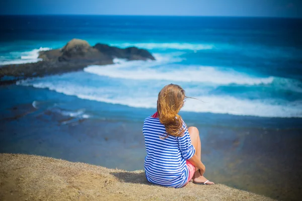 Meisje zitten op het strand — Stockfoto