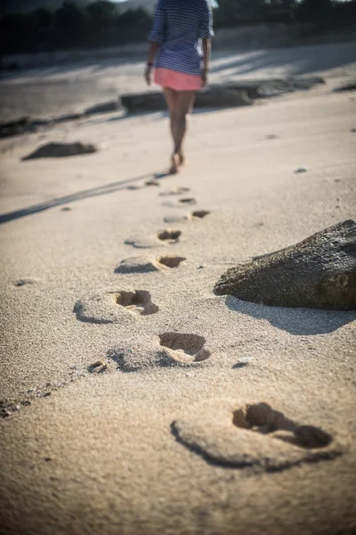 Kvinde går alene på en øde strand - Stock-foto