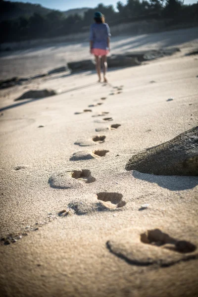 Mulher caminha sozinha em uma praia deserta — Fotografia de Stock