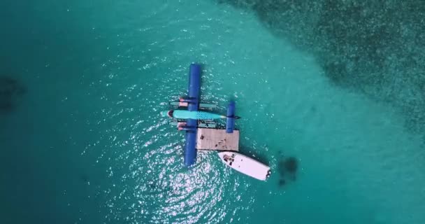 Vue aérienne d'un bateau à moteur s'approchant d'un hydravion flottant en eau turquoise — Video