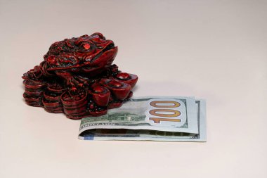 100 dolarlık banknotun üzerinde duran bir feng shui para kurbağası. Geleneksel feng shui tedavilerinden biri..